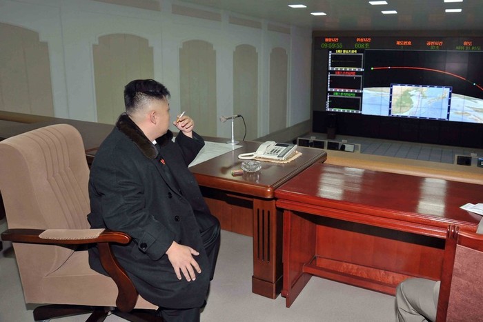 Ông Kim Jong-un ngồi hút thuốc và theo dõi đường đi của tên lửa đẩy trên màn hình