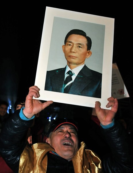 Một cử tri ủng hộ bà Park Geun-hye mang theo ảnh người cha quá cố của bà, Tổng thống Park Chung-hee