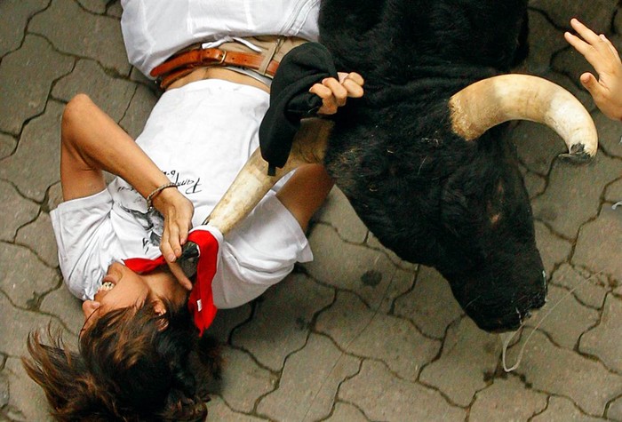 Một người đàn ông vật lộn với một con bò tại lễ hội San Fermin ở Pamplona, Tây Ban Nha, vào ngày 7 tháng Bảy.