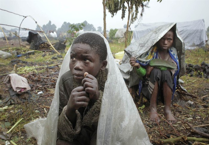 Những đứa trẻ phải dời Congo đi tị nạn trú mưa trong những tấm nhựa, ảnh chụp ngày 8 tháng Tám, khi chúng đang chờ đợi viện trợ trong Kibati, phía bắc Goma, phía đông Congo.