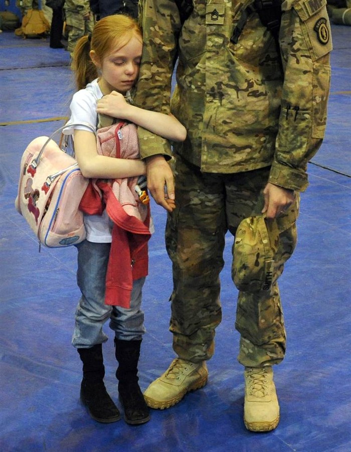 Alyssa Smith ôm ấp vuốt ve cánh tay của cha cô, Jason Smith, khi ông trở về từ Afghanistan vào ngày 24 tháng 3 tại Anchorage, Alaska.