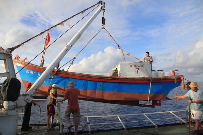 Ngư dân Trung Quốc cẩu thuyền nhỏ hạ thủy chuẩn bị đánh bắt trái phép, vơ vét tài nguyên nghề cá ở khu vực Tây Nam quần đảo Trường Sa của Việt Nam