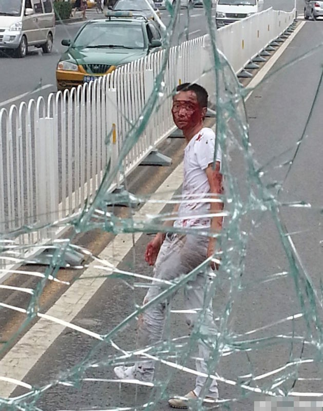Người đàn ông máu mê be bét sau khi nhảy từ cầu vượt đường bộ xuống và rơi trúng xe bus làm vỡ tan kính trước.