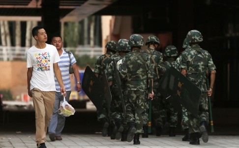 Cảnh sát vũ trang Trung Quốc tuần tra trên 1 đường phố ở Tân Cương.