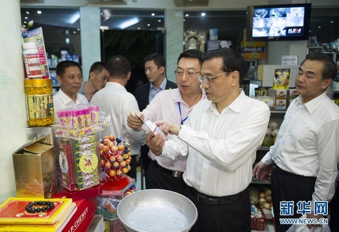 Thủ tướng Trung Quốc xem một số mặt hàng bày bán, bên phải là ông Vương Nghị, Ngoại trưởng Trung Quốc.