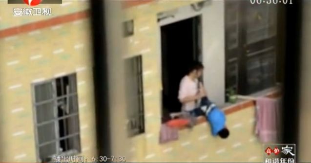 Người mẹ cầm chân cậu bé dốc ngược cổ ra ngoài lan can tầng 7 chung cư, một cách dạy con phản giáo dục và vô cùng nguy hiểm.