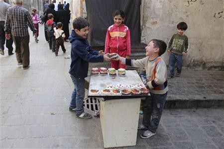Trẻ em Syria bán bánh trên đường phố Aleppo.