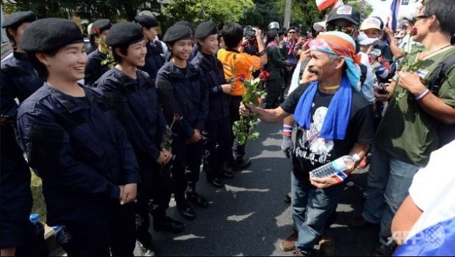 Các nữ cảnh sát Thái Lan cười tươi rói chào đón những người biểu tình.