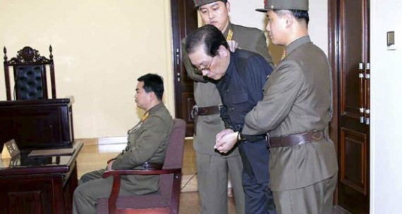 Bức ảnh Jang Song-thaek trước tòa bị 2 nhân viên an ninh "ấn đầu, dúi cổ" đầy kịch tính và chưa từng có tiền lệ ở Bắc Triều Tiên.