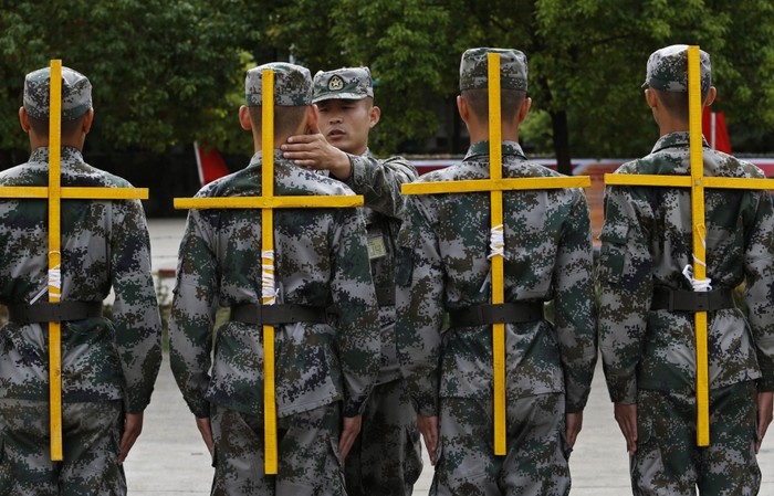 Tân binh Trung Quốc huấn luyện điều lệnh đội ngũ phải đeo giá chữ thập giữ cho lưng thẳng.
