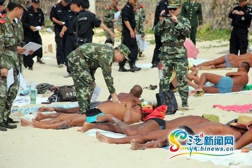 Cảnh sát Tam Á được điều động tham gia tuyên truyền, vận động người dân và khách du lịch không &quot;tắm truồng, thả rông&quot;ngoài bãi biển.