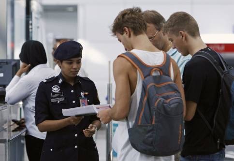Nhân viên an ninh sân bay quốc tế Kuala Lumpur kiểm tra hộ chiếu, làm thủ tục xuất nhập cảnh. Hình minh họa.