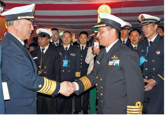 Chỉ huy trưởng tàu chiến Ấn Độ INS Shivalik (phải) tiếp ông Lợi và quan chức quân sự các nước ghé thăm tàu, nhưng từ chối yêu cầu được vào thăm phòng chỉ huy chiến hạm của ông Tư lệnh Hải quân Trung Quốc (trái).
