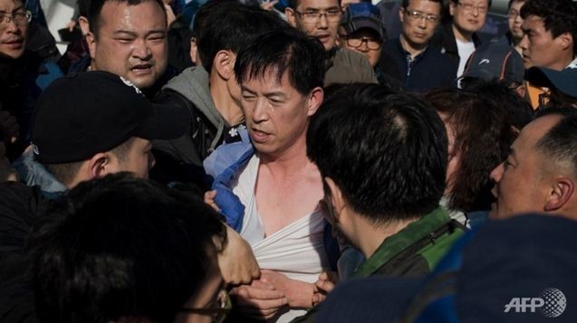 Ông Choi Sang-hwan (giữa) trong vòng vây của người nhà các nạn nhân đắm phà Sewol.