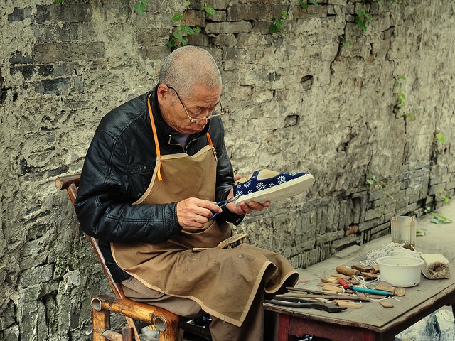 Một người thợ đóng giày ngồi gọn trong 1 con phố ở Bắc Kinh cũng có thể là một &quot;điệp viên tình báo chống khủng bố&quot;, hình minh họa.