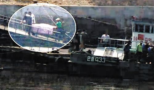 Lực lượng cứu hộ Bắc Triều Tiên đưa thi thể 2 phi công trong vụ tai nạn ra khỏi hiện trường.