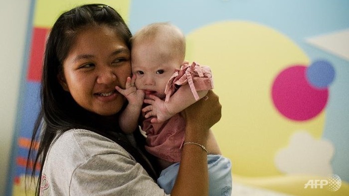 Pattaramon Chanbua, một phụ nữ Thái Lan đẻ thuê và đứa bé mắc hội chứng Down bị &quot;cha mẹ sinh học&quot; bỏ lại. Ảnh: Channel News Asia/AFP.