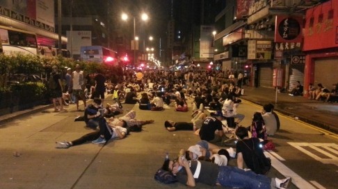 Người biểu tình mệt nhoài nằm trên đường phố sau một đêm đụng độ với cảnh sát.