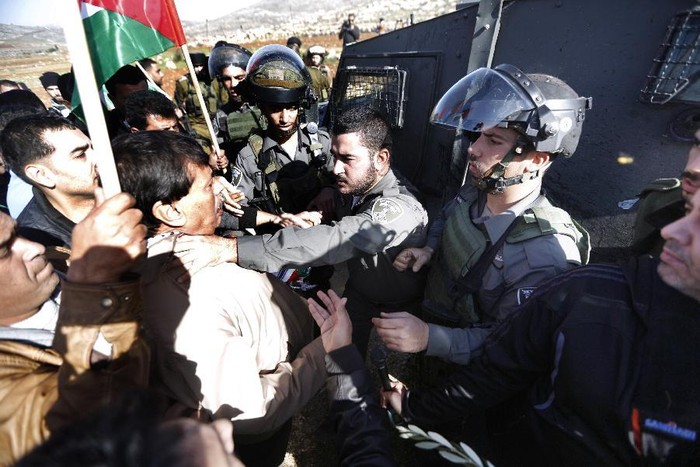 Lính Israel túm cổ ông Abu Ein trước khi đâm quan chức này. Ảnh: Yahoo News/AFP.