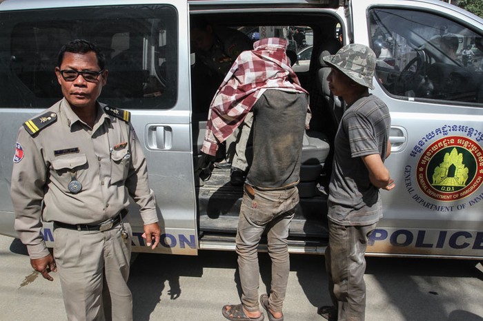 Một người đàn ông gốc Việt bị Cảnh sát Phnom Penh áp giải lên xe vì không xuất trình được giấy tờ ngay lập tức.