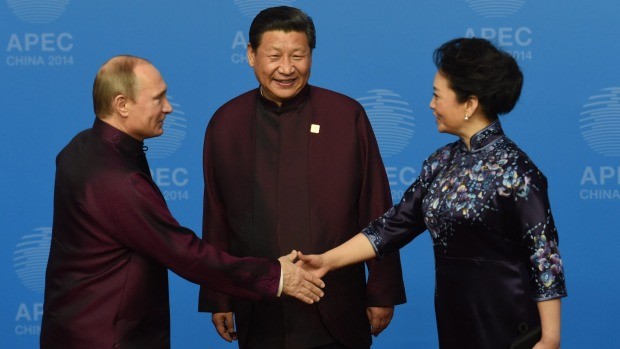 Tổng thống Nga Vladimir Putin bắt tay Đệ nhất phu nhân Trung Quốc Tập Cận Bình khi sang Trung Quốc dự hội nghị APEC.