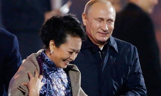 Ông Putin đã có một cử chỉ &quot;gây chú ý&quot; khi khoác chiếc áo choàng lên vai bà Bành Lệ Viện, phu nhân của ông Tập Cận Bình tại hội nghị thượng đỉnh APEC năm ngoái. Ảnh: The Guardian.