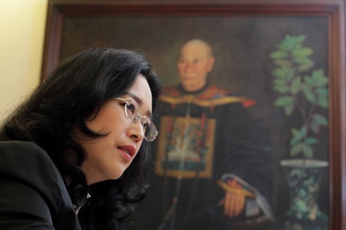 Bà Olivia Limpe Aw, hậu duệ đời thứ 5 của Lim Tua-co, một tướng quân đội nhà Mãn Thanh đã sang Philippines làm ăn bên chân dung ông tổ của mình. Ảnh: SCMP.