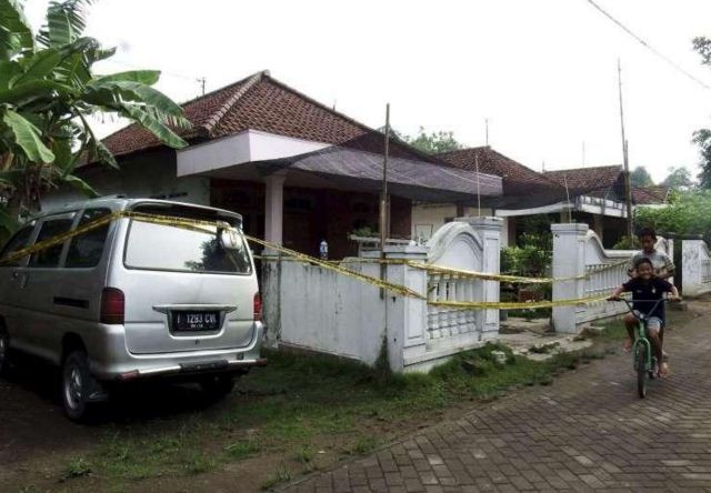 Trẻ em vui chơi quanh một ngôi nhà được rào cảnh báo, sau cuộc đột kích của cảnh sát chống khủng bố tại Mojokerto, Đông Java, Indonesia vào ngày 20/12. Ảnh: Reuters.