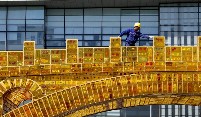 Một công nhân Trung Quốc đang trang trí bên ngoài trung tâm hội nghị Diễn đàn quốc tế Một vành đai, một con đường, ảnh: AP / SCMP.