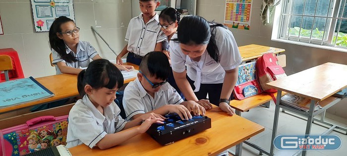 Em Phạm Thị Thùy Trang đang hướng dẫn học sinh Trường nuôi dạy trẻ khiếm thị Hữu Nghị tỉnh Bà Rịa- Vũng Tàu sử dụng thiết bị học tập do mình sáng chế (Ảnh: Nhân vật cung cấp).