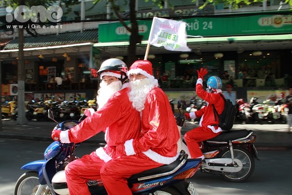 Thay vì cưỡi tuần lộc, các ông già Noel đèo nhau bằng xe máy trong trang phục đỏ rực như thắp lửa các tuyến đường trung tâm TP HCM.