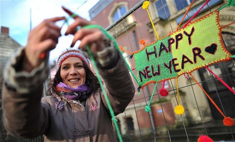 Một người đan len nghiệp dư đan dòng chữ "Chúc mừng năm mới" trên đường phố Hanover của Đức.