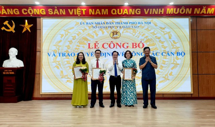 Lãnh đạo Sở Giáo dục và Đào tạo Hà Nội trao quyết định, tặng hoa chúc mừng các cán bộ được bổ nhiệm lại. (Ảnh: Sở Giáo dục và Đào tạo Hà Nội)