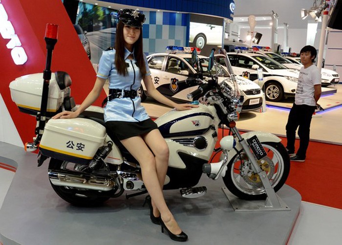 Nữ người mẫu xinh đẹp trong trang phục cảnh sát bên cạnh chiếc xe máy sang trọng.