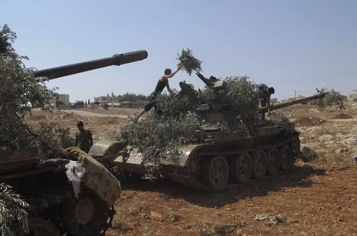 Các binh sĩ thuộc Lực lượng Quân đội Tự do Syria ngụy trang xe tăng ở Anadan, phía bắc Aleppo.