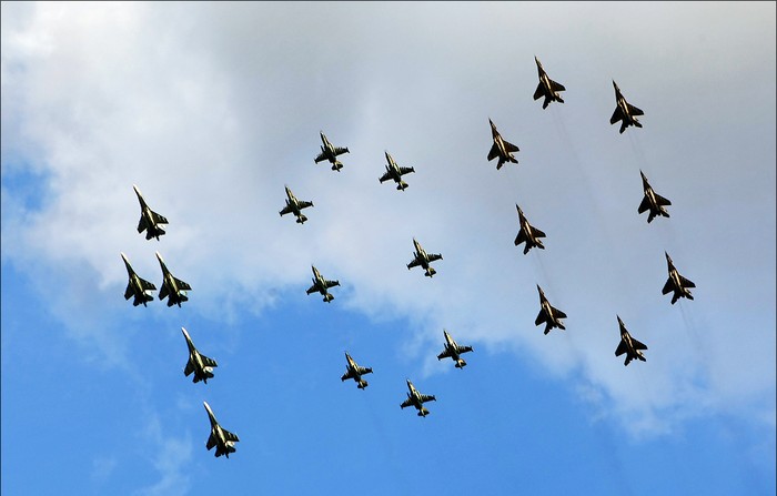 Sau đó là 5 chiếc Su-27, 8 chiếc Su-25 và 8 máy bay MiG-29 xếp thành hình số 100 trên bầu trời.