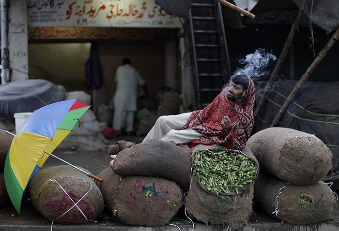  Một người bán rau nghỉ hút thuốc ở Islamabad, Pakistan