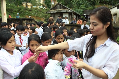Hoa hậu Lisa Vân Anh vui vẻ chia từng chiếc cặp tóc cho các em nữ
