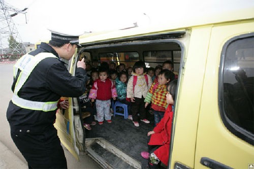 Một cảnh sát đếm có tổng cộng có 36 đứa trẻ, hầu hết đứng trong một chiếc xe tải thiết kế cho 11 người ngồi, ở Xiangyang, tỉnh Hồ Bắc miền Trung, Trung Quốc ngày 23/11.