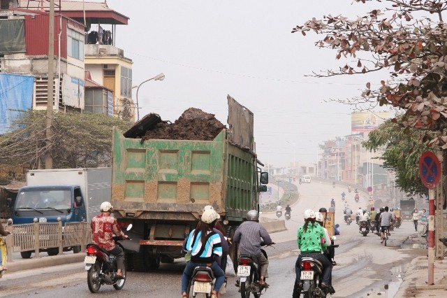 Xe tải chở đất che chắn tạm bợ đã vương vãi phế liệu ra đường