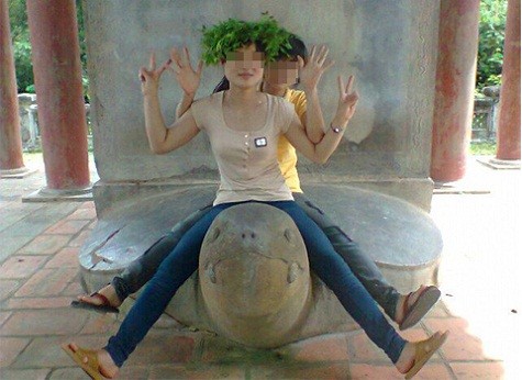 Hình ảnh phản cảm của hai thiếu nữ khi ngồi lên cả đầu rùa tại khu Văn Miếu - Quốc Tử Giám