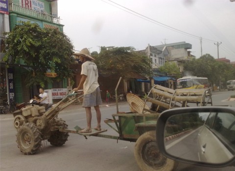 Bức ảnh này chụp tại thị xã Sơn Tây - Hà Nội. Một bác đứng lái máy cày hiên ngang chạy cắt ngang phố (Ảnh: Hoàng Giang).