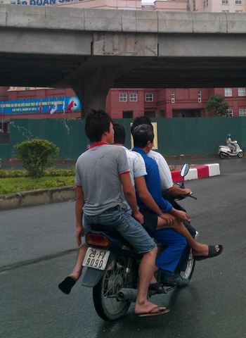 4 người ngồi trên xe máy chạy dưới chân cầu Linh Đàm, Hà Nội.