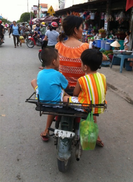 Hai đứa bé ngồi chênh vênh trên "thùng" xe phía sau, chụp tại Đức Hòa, Long An. Ảnh: Nguyễn Nhật Khánh