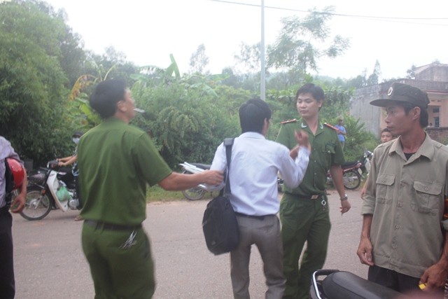 Phóng viên Hải Sơn bị hai đồng chí công an "mời" về làm việc bằng cách túm tay kéo đi.