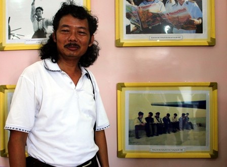 Nhà báo Tâm Phùng (báo NNVN) đứng bên bức ảnh của mình chụp tại đảo Trường Sa