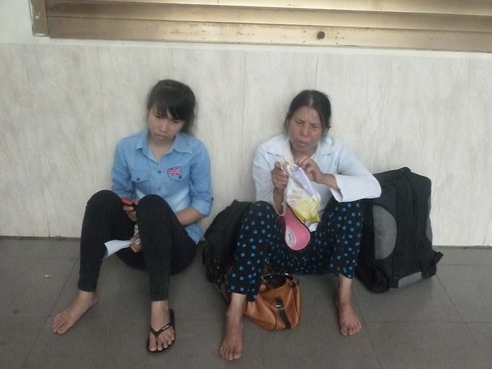 Cô Quang mệt mỏi ngồi ăn bánh mì tại bến xe Mỹ Đình sau hơn 3 tiếng ngồi xe khách