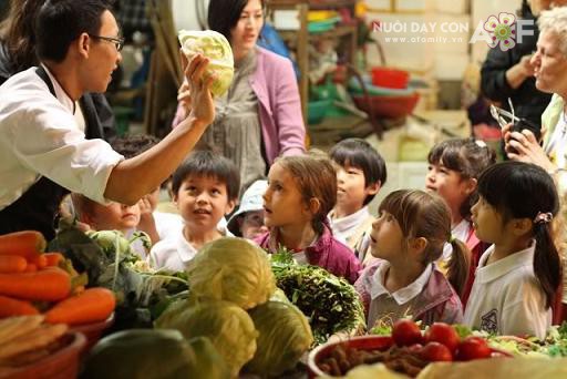 Anh Nguyễn Mạnh Hùng (mặc áo tạp dề đen, đeo kính) và các em nhỏ trong buổi đi chợ