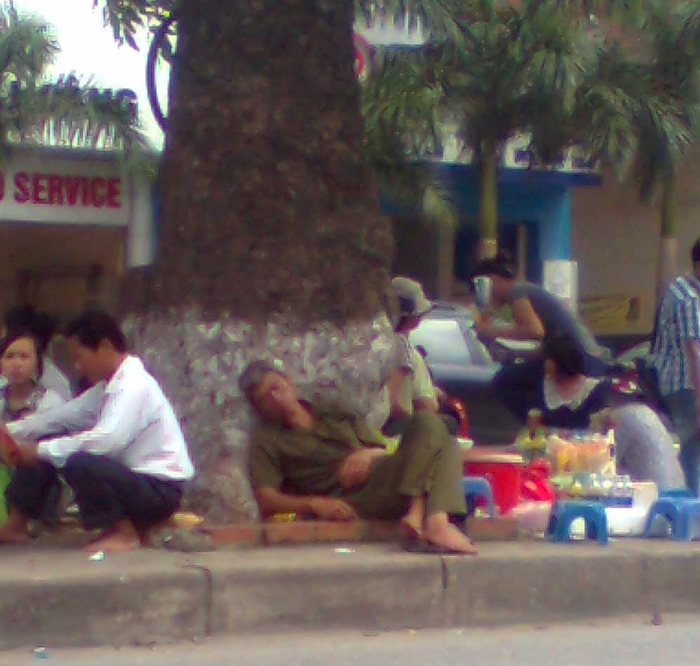 Người đàn ông ngủ gục bên lề đường trong lúc chờ con thi Đại học
