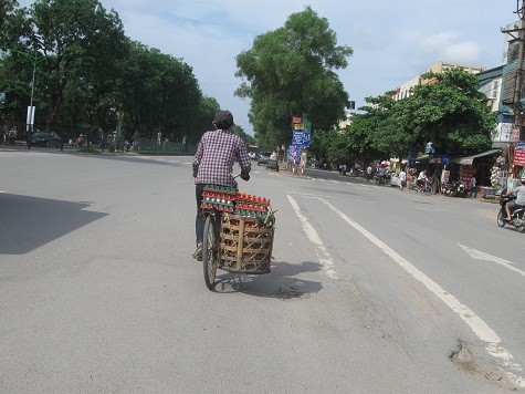 Người phụ nữ chở sọt trứng trổ tài lái xe thăng bằng trên chiếc xe đạp “trần truồng”. Đường Nguyễn Trãi, Thanh Xuân, Hà Nội.